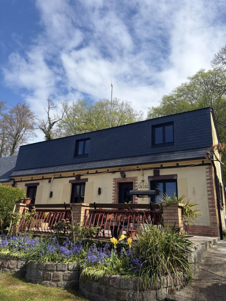 Maison de charme avec jardin fleuri et toiture ardoise neuve posée par Houisse Couverture